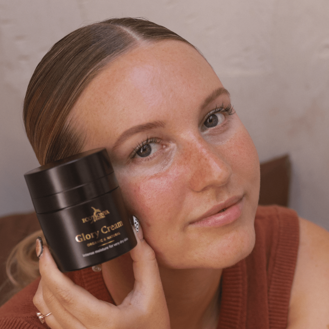 Woman holding Eco By Sonya Glory Cream jar close to her face against a neutral background, natural organic rich moisturiser from Australia.