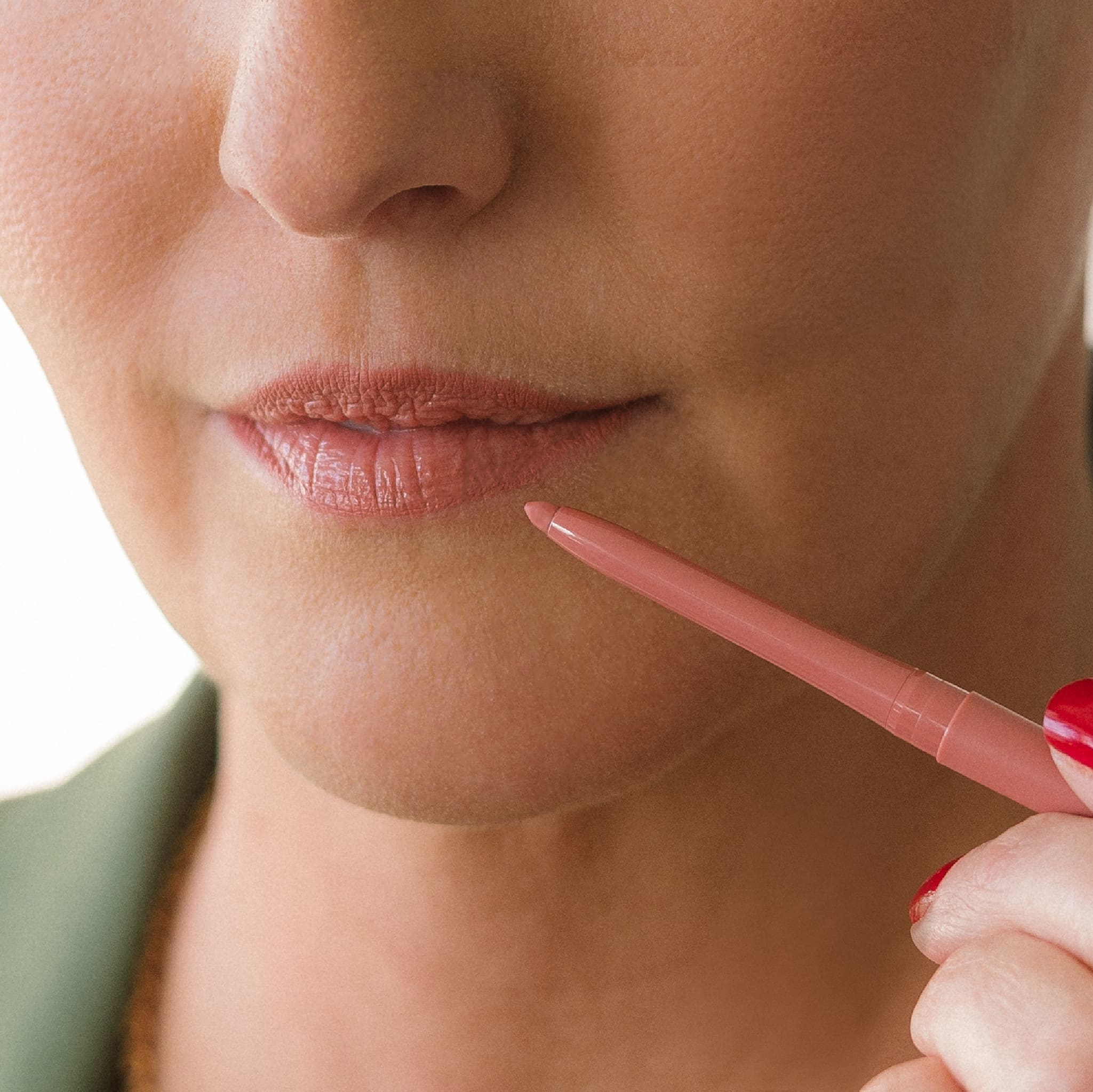 Close-up of a model’s lips holding Eco By Sonya Perfect Nude lip liner against her lips.